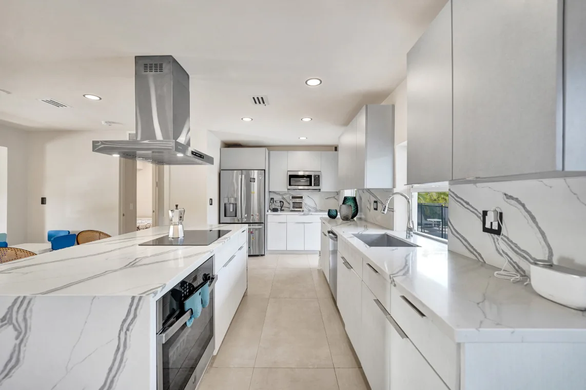 Custom kitchen remodel with waterfall marble island by Blank Construction in Miami, FL